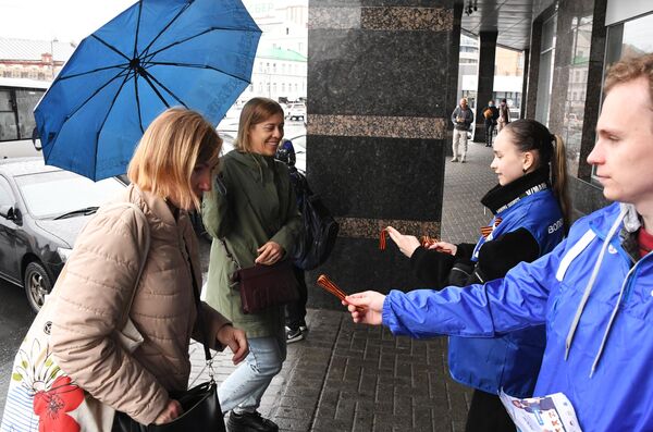 Campaign participants engage with women passing by a Vladivostok mall as part of the national St. George Ribbon movement. - Sputnik International