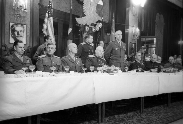 پذیرایی به مناسبت جشن نیروهای متفقین در روز البه.  مارشال اتحاد جماهیر شوروی ایوان کونیف (چهارمین نفر از چپ) و ژنرال ارتش ایالات متحده عمر نلسون بردلی (ایستاده) روی میز نشسته اند.  - اسپوتنیک بین المللی