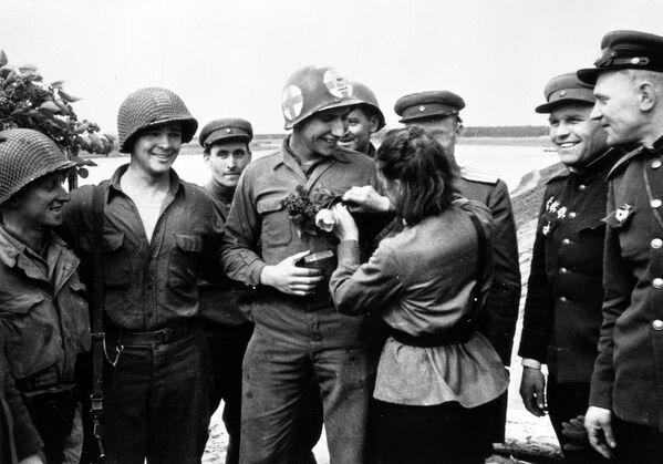 لیوبوف کازیچنکو پرستار شوروی به سرباز آمریکایی کارل رابینسون گل هدیه می دهد.  - اسپوتنیک بین المللی