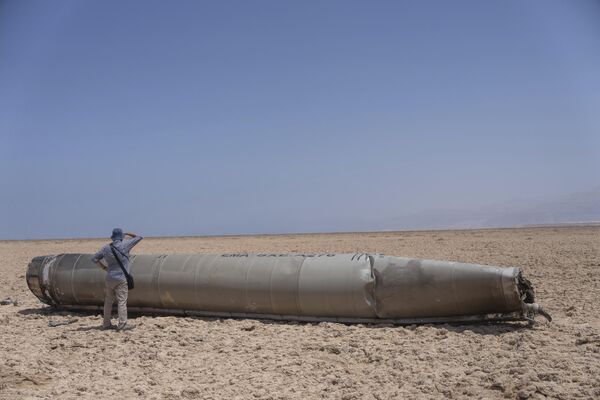یک عکاس خبری در حال بررسی بخشی از یک موشک ایرانی است.  - اسپوتنیک بین المللی