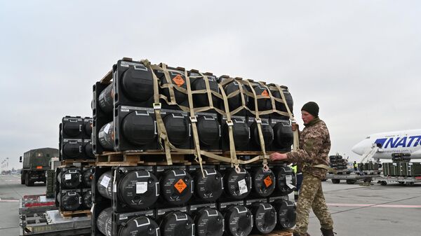 A Ukrainian serviceman is at work to receive the delivery of FGM-148 Javelins, American man-portable anti-tank missiles provided by the US to Ukraine as part of a military support, at Kiev's airport Borispol on February 11, 2022. - Sputnik International