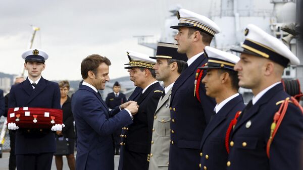 French President Emmanuel Macron decorates soldiers from the deck of the amphibious helicopter carrier Dixmude docked in the French Navy base of Toulon, southern France, Wednesday, Nov. 9, 2022 - Sputnik International