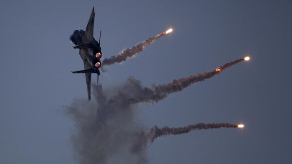 An Israeli Air Force fighter jet releases flares during an acrobatics display during a graduation ceremony in the Hatzerim air force base near the southern city of Beersheba, Israel, Thursday, Dec. 27, 2012 - Sputnik International