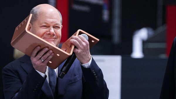 German Chancellor Olaf Scholz holds a copper conductor as he visits the booth of German manufacturing company of power distribution gear and IT infrastructure Rittal during an opening tour of the Hanover technology Fair (Hannover Messe) on April 22, 2024 in Hanover, northern Germany. - Sputnik International