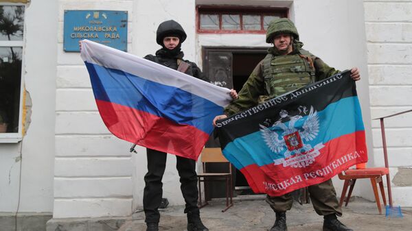 Servicemen hold flags in Donetsk People's Republic. File photo. - Sputnik International