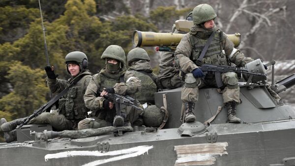 Russian servicemen ride a military vehicle. - Sputnik International
