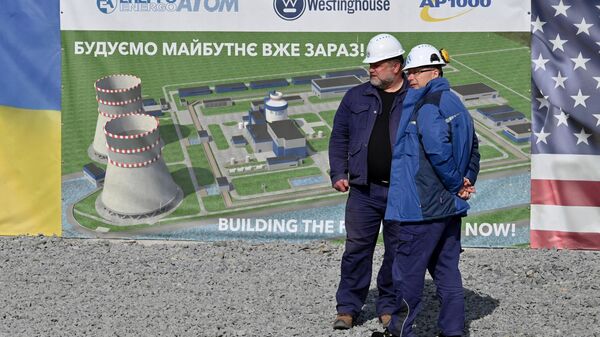 Employees stand next a placard during the launching ceremony implementation of preparatory activities before the construction of power units 5, 6 using the American Westinghouse technology at the Khmelnytsky Nuclear Power Plant (KhNPP) near Ukrainian city of Khmelnytsky on April 11, 2024. - Sputnik International