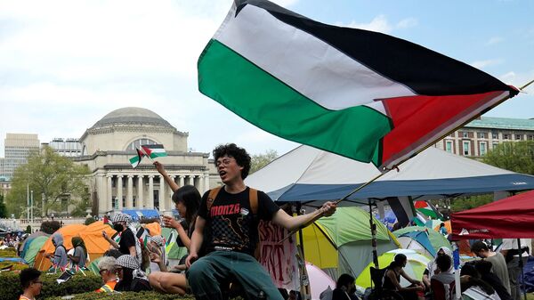 Протестующие размахивают палестинскими флагами на Западной лужайке Колумбийского университета в Нью-Йорке - Sputnik International