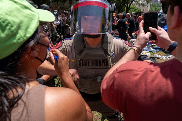 Pro-Palestinian protestors confront a Texas State trooper at the University of Texas (April 29, 2024). - Sputnik International