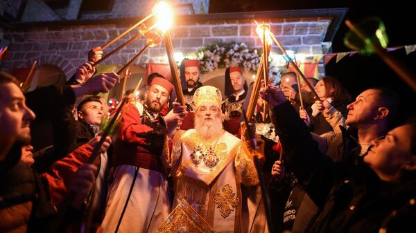 Macedonian Orthodox Christians light candles from the holy fire that arrived from Jerusalem during an Easter service at the Saint Jovan Bigorski monastery in Mavrovo, some 115km west from the capital Skopje, early on May 5, 2024.  - Sputnik International