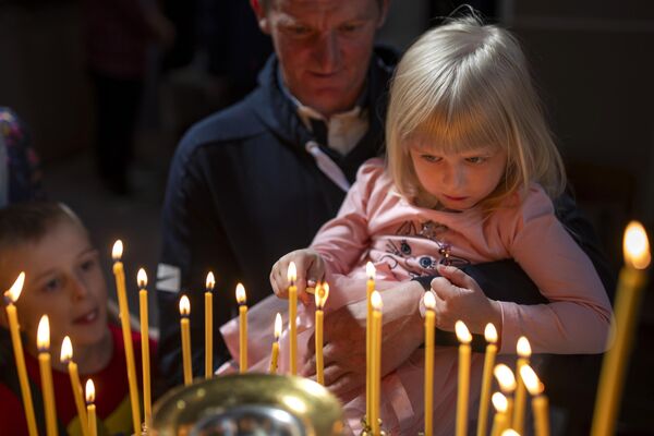 Believers light candles after a cake and Easter egg blessing ceremony at the Orthodox Church of the Holy Spirit in Vilnius, Lithuania. - Sputnik International