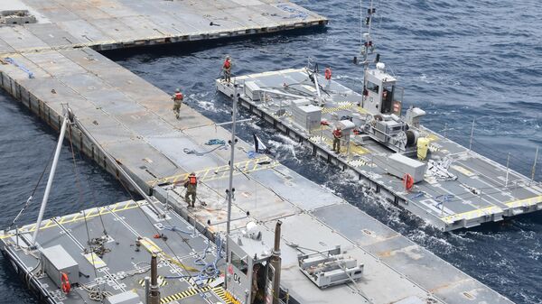 In this image provided by the U.S. Army, soldiers assigned to the 7th Transportation Brigade (Expeditionary) and sailors attached to the MV Roy P. Benavidez assemble the Roll-On, Roll-Off Distribution Facility (RRDF), or floating pier, off the shore of Gaza in the Mediterranean Sea on April 26, 2024. (U.S. Army via AP) - Sputnik International