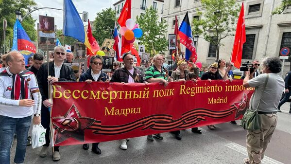 Immortal Regiment participants on a ceremonial march in Spain. Locals hold family portraits, Victory Banners and flags of new Russian regions the Lugansk People&#x27;s Republic (left) and Donetsk People&#x27;s Republic (right). - Sputnik International