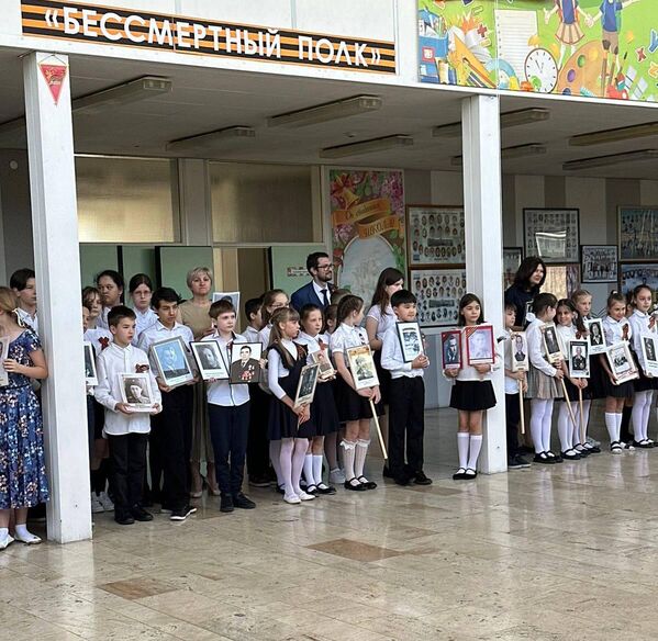 Middle schoolers hold old portraits of their ancestors who fought in the Great Patriotic War in a Hungarian school. - Sputnik International