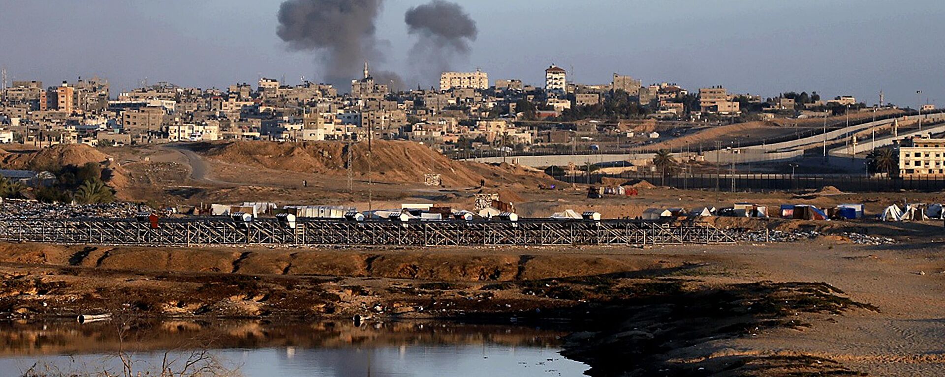 دود پس از حمله هوایی اسرائیل به ساختمان های نزدیک دیوار جدایی بین مصر و رفح، در جنوب نوار غزه، دوشنبه، 6 مه 2024 - اسپوتنیک بین المللی 1920 05/10/2024 بر می خیزد.