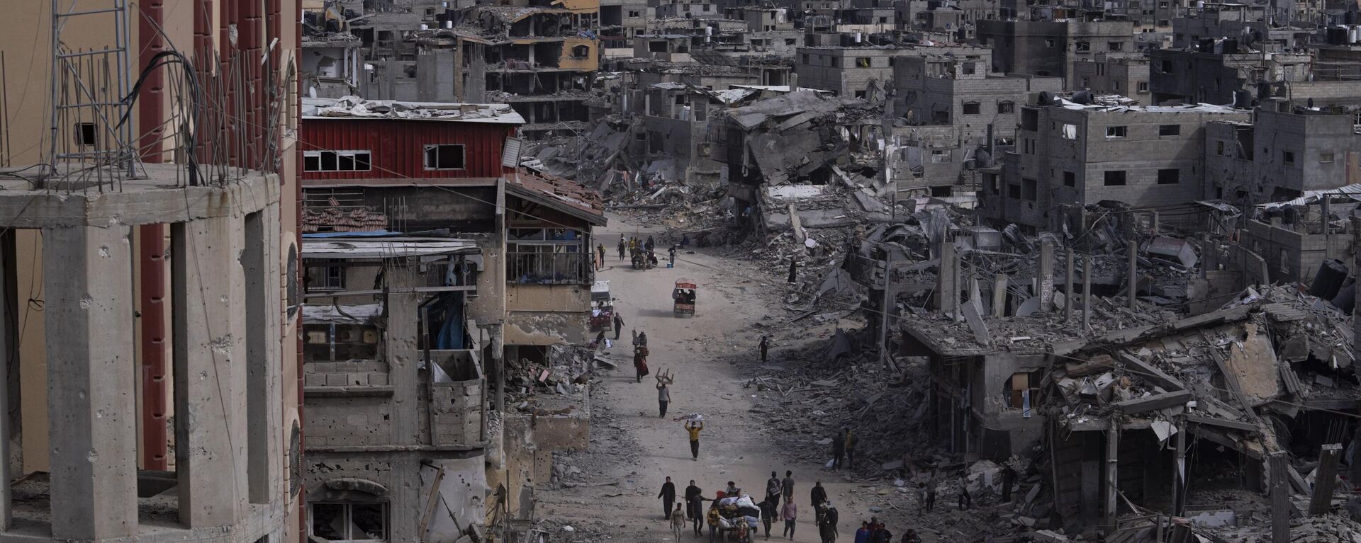 Palestinians walk through the destruction in the wake of an Israeli air and ground offensive in Khan Younis, southern Gaza Strip, Monday, April 8, 2024 - Sputnik International, 1920, 08.05.2024