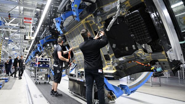 Employees of German car maker Mercedes-Benz work on the bottom side of an EQS passenger car at the Mercedes-Benz manufacturing plant in Sindelfingen, southwestern Germany, on February 13, 2023. - Sputnik International