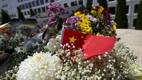 A Chinese flag is placed near flowers on a monument at the site of a former Chinese Embassy in Belgrade, Serbia, Monday, April 29, 2024. During NATO bombing campaign, in 1999, jets bombed the Chinese Embassy in Belgrade, killing three people and at least 20 were injured. Chinese leader Xi Jinping will spend the bulk of his five-day tour in Europe this week in two small countries at the continent’s eastern half, Hungary and Serbia. (AP Photo/Darko Vojinovic) - Sputnik International