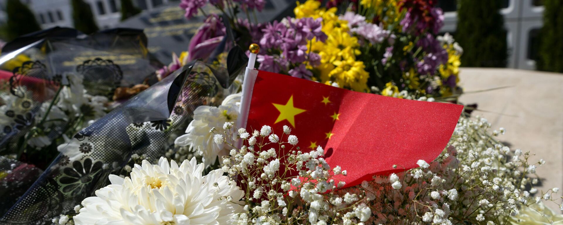 A Chinese flag is placed near flowers on a monument at the site of a former Chinese Embassy in Belgrade, Serbia, Monday, April 29, 2024. During NATO bombing campaign, in 1999, jets bombed the Chinese Embassy in Belgrade, killing three people and at least 20 were injured. Chinese leader Xi Jinping will spend the bulk of his five-day tour in Europe this week in two small countries at the continent’s eastern half, Hungary and Serbia. (AP Photo/Darko Vojinovic) - Sputnik International, 1920, 08.05.2024