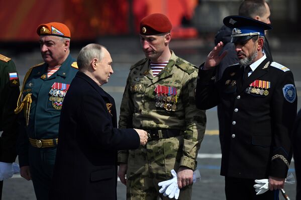 Russian President Vladimir Putin speaks with decorated officers and soldiers who have arrived from the special military operation zone to take part in the Victory Day parade on Red Square. - Sputnik International