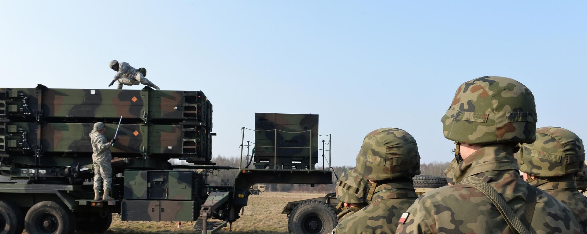 Polish soldiers watch as US troops from the 5th Battalion of the 7th Air Defense Regiment emplace a launching station of the Patriot air and missile defence system at a test range in Sochaczew, Poland, on  March 21, 2015. - Sputnik International, 1920, 29.05.2024