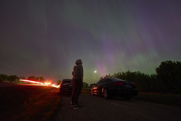 People stop along a country road near London, Ontario in Canada to watch the Northern lights or aurora borealis. - Sputnik International