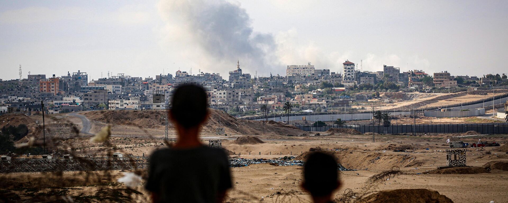 Boys watch smoke billowing during Israeli strikes east of Rafah in the southern Gaza Strip on May 13, 2024, amid the ongoing conflict between Israel and the Palestinian militant group Hamas - Sputnik International, 1920, 08.06.2024