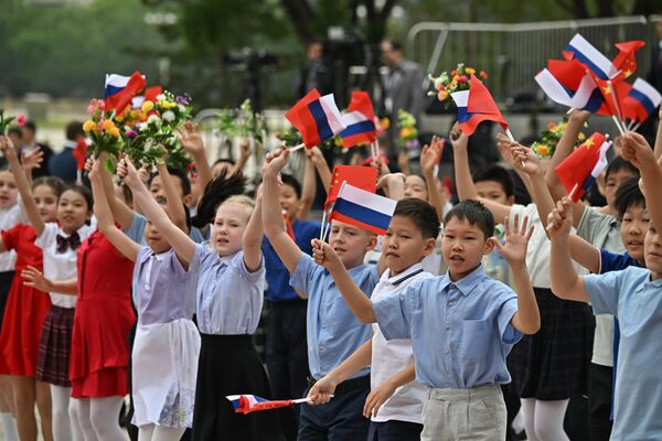 Children waving Russian and Chinese flags prior to the meeting - Sputnik International