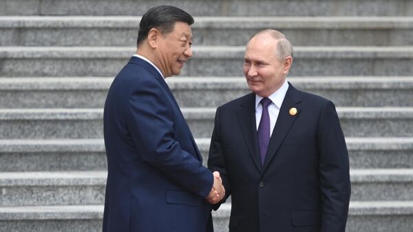 Russian President Vladimir Putin shake hands with Chinese President Xi Jinping during a welcome ceremony outside the Great Hall of the People in Beijing, China. - Sputnik International