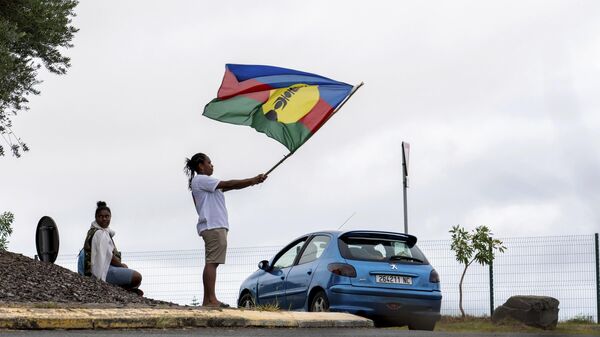 A woman waves a Kanak and Socialist National Liberation Front (FLNKS) flag in Noumea, New Caledonia, Wednesday May 15, 2024 - Sputnik International