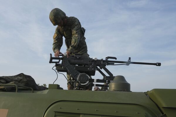 A Chinese soldier prepares a weapon on an armored vehicle.  - Sputnik International