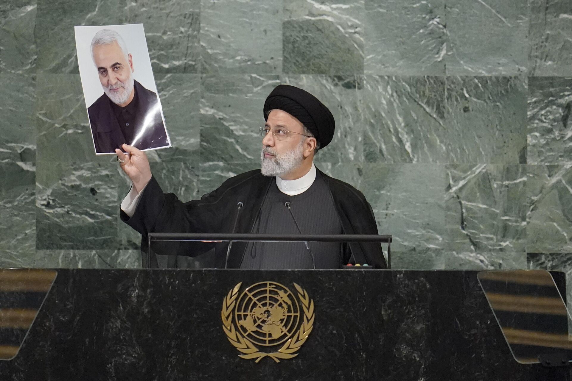 President of Iran Ebrahim Raisi holds up a photo of slain Iranian Gen. Qassem Soleimani, as he addresses the 77th session of the United Nations General Assembly - Sputnik International, 1920, 02.01.2025