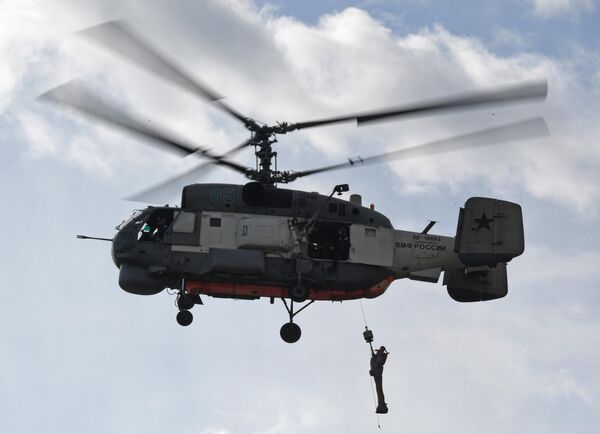 A Ka-27 search helicopter lifts a dummy on board as part of honing crew skills to rescue victims. - Sputnik International