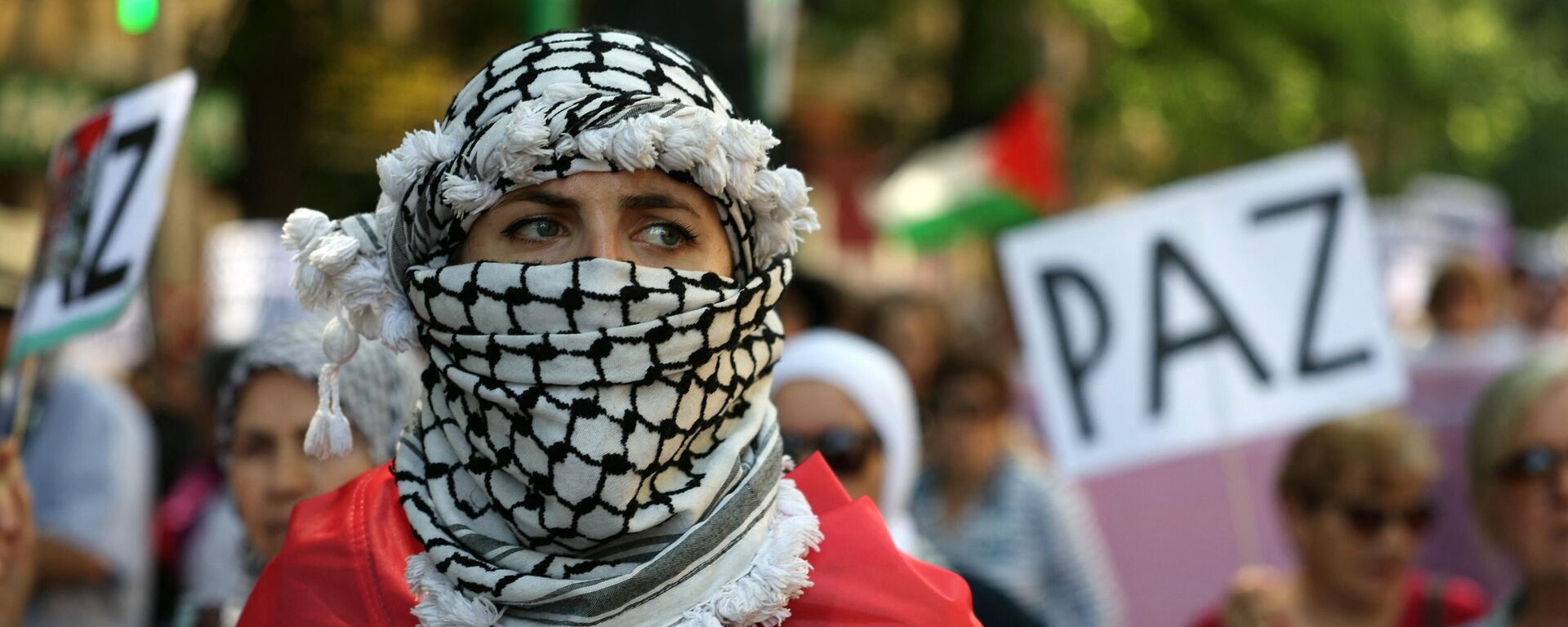 A woman wrapped in a Palestinian flag and wearing a keffiyeh takes part in a demonstration in support of the Palestinian people from the Gaza Strip, in Madrid on May 11, 2024.  - Sputnik International, 1920, 22.05.2024