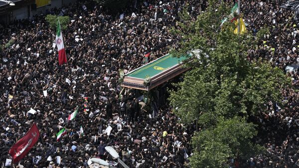Iranians follow a truck carrying coffins of the late President Ebrahim Raisi and his companions who were killed in a helicopter crash on Sunday in a mountainous region of the country's northwest, during a funeral ceremony for them in Tehran, Iran, Wednesday, May 22, 2024. - Sputnik International