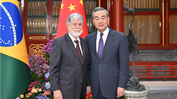 Screenshot showing Wang Yi (right), China’s foreign minister, welcoming Celso Amorim, a top adviser to Brazilian President Luiz Inacio Lula da Silva, in Beijing on Thursday, May 23, 2024.  - Sputnik International