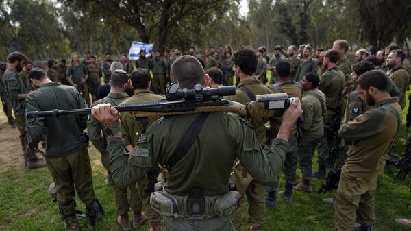 Israeli soldiers are briefed after coming back from the Gaza Strip at a staging area in southern Israel, Sunday, Dec. 17, 2023 - Sputnik International