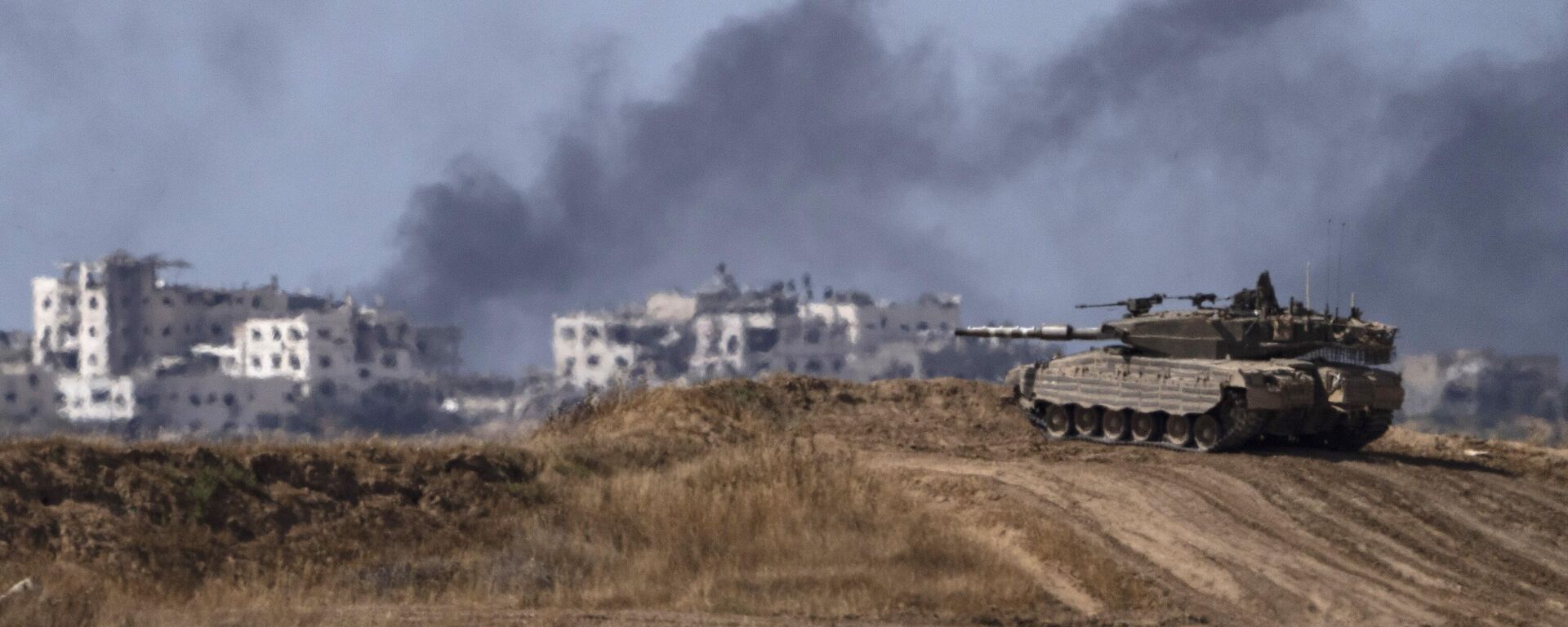 Backdropped by smoke rising to the sky after an explosion in the Gaza Strip, an Israeli tank stands near the Israel-Gaza border as seen from southern Israel, Monday, May 13, 2024 - Sputnik International, 1920, 26.05.2024