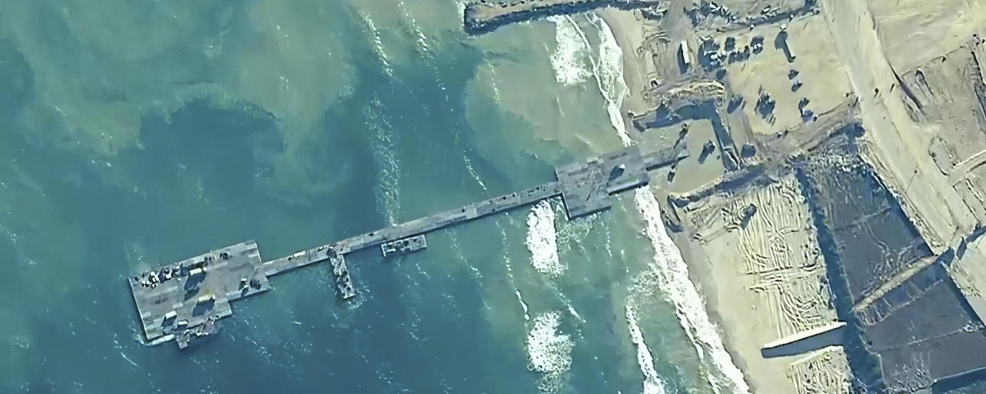 The image provided by US Central Command, shows US Army soldiers assigned to the 7th Transportation Brigade (Expeditionary), U.S. Navy sailors assigned to Amphibious Construction Battalion 1, and Israel Defense Forces placing the Trident Pier on the coast of Gaza Strip on Thursday, May 16, 2024. The temporary pier is part of the Joint Logistics Over-the-Shore capability. The U.S. military finished installing the floating pier on Thursday, with officials poised to begin ferrying badly needed humanitarian aid into the enclave besieged over seven months of intense fighting. (U.S. Central Command via AP) - Sputnik International, 1920, 27.05.2024