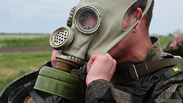 A Russian serviceman puts on a gas mask as takes part in the 2022 Seaborne Assault naval infantry units contest at Khmelevka training ground, in Kaliningrad region, Russia. - Sputnik International