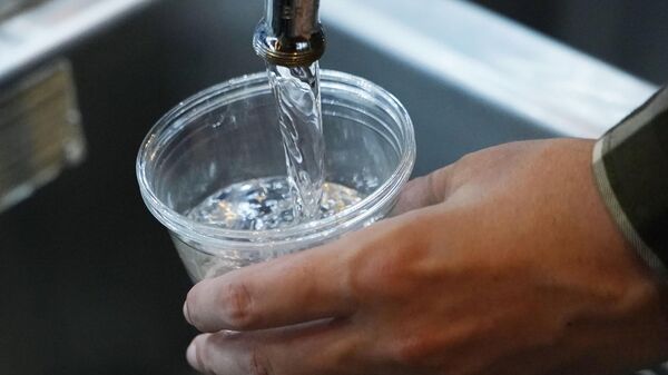 A cup of water is drawn from a faucet at Johnny T's Bistro and Blues, a midtown Jackson, Miss., restaurant and entertainment venue, Thursday, Sept. 1, 2022 - Sputnik International