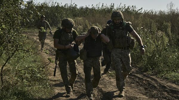 Ukrainian servicemen help to evacuate a wounded soldier on Aug. 30, 2023.  - Sputnik International