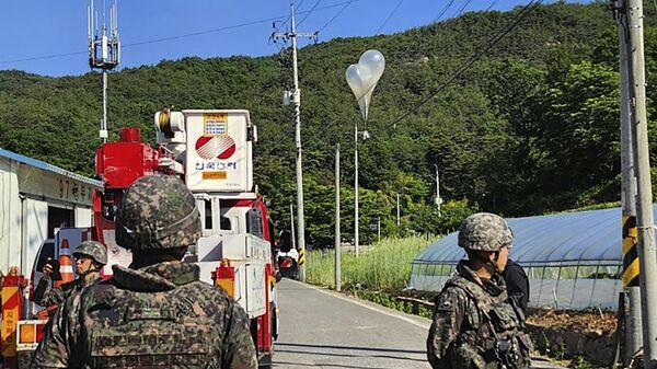 FILE - In this photo provided by Jeonbuk Fire Headquarters, balloons with trash presumably sent by North Korea, hang on electric wires as South Korean army soldiers stand guard in Muju, South Korea, on Wednesday, May 29, 2024. - Sputnik International