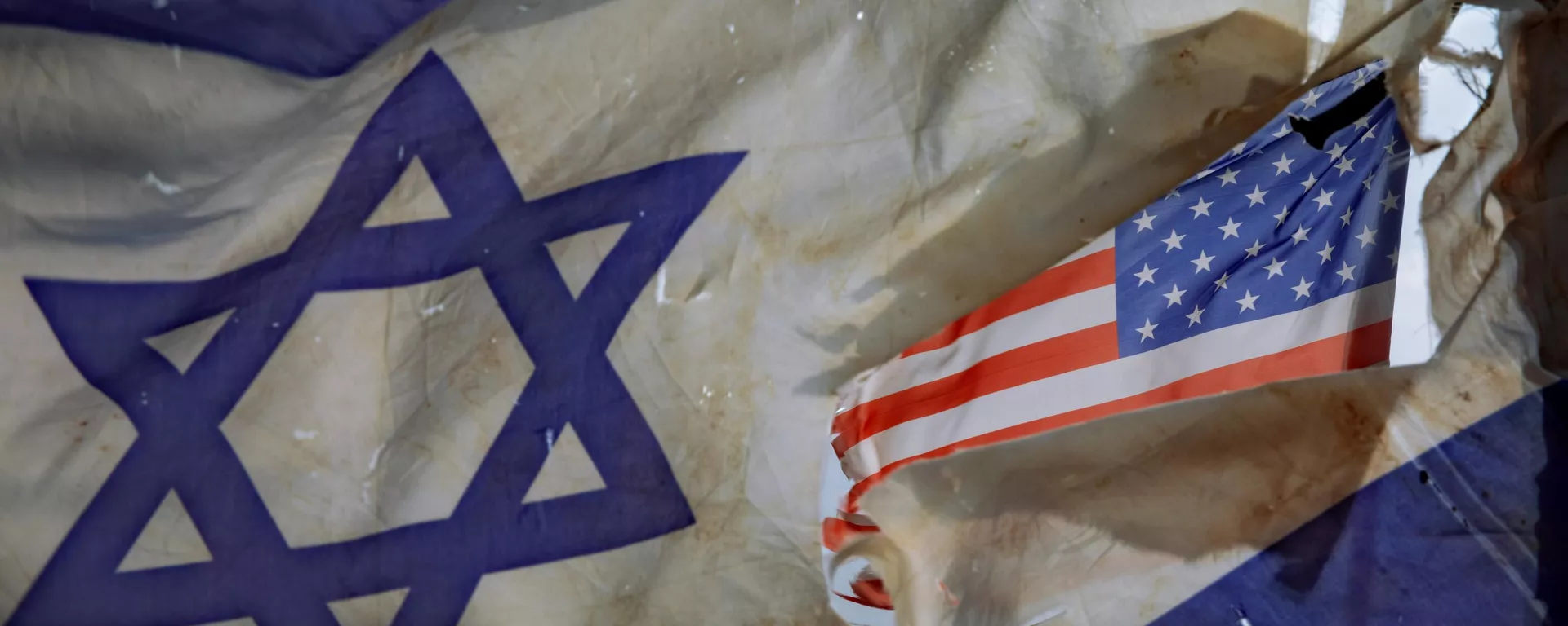 A US flag is seen through a hole torn in an Israel national flag, as they wave in the wind at a horse ranch, near the southern Israeli town of Sderot, Friday, Nov. 20, 2020 - Sputnik International, 1920, 03.10.2024