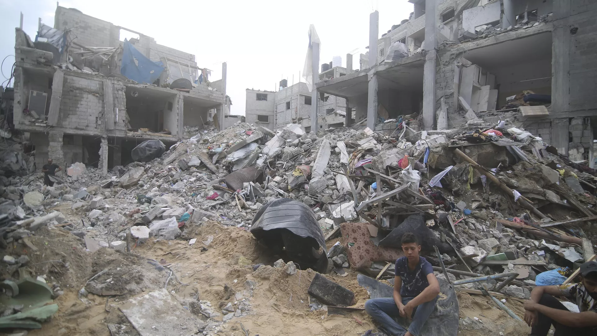 Palestinians sit by the rubble Abu Helal family in Rafah refugee camp, Gaza Strip, Monday, Oct. 9, 2023. The strike killed dozens of people - Sputnik International, 1920, 04.07.2024