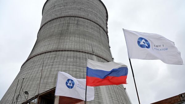A Russian national flag and flags with the logo of Rosatom flutters at the construction site of a cooling tower at the Kursk II nuclear power plant near the village of Makarovka outside Kurchatov, Kursk region, Russia - Sputnik International