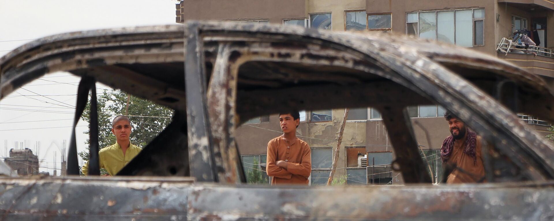 Locals view a vehicle damaged by a rocket attack in Kabul, Afghanistan. Rockets struck a neighborhood near Kabul's international airport on Monday amid the ongoing US withdrawal from Afghanistan. - Sputnik International, 1920, 08.06.2024