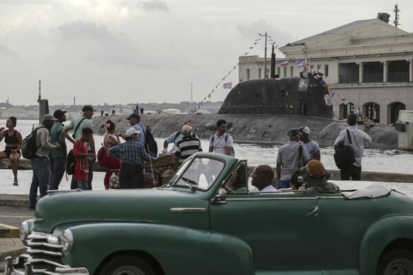 A convertible car drives by as people watch the anticipated visit of the Russian ships. - Sputnik International