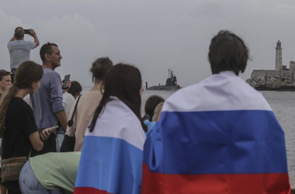 People wearing Russian flags watch the Kazan submarine arrive at the port of Havana. The Russian warships reached Cuban waters on Wednesday ahead of planned military exercises in the Caribbean. - Sputnik International