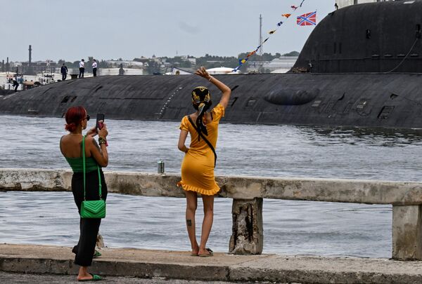 A woman waves to crew members of the nuclear-powered submarine Kazan, part of the Russian naval detachment visiting Cuba. - Sputnik International